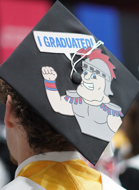 A graduation cap decorated with a cartoon Tommy Titan saying 