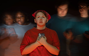 A promotional photo for The Grown Ups, where three students are holding phones.