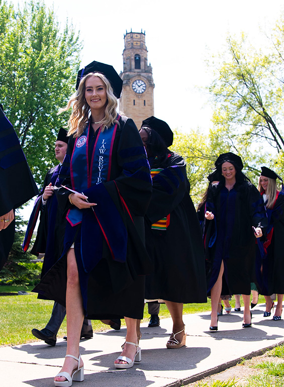 Graduates walk past the clock tower during the processional.
