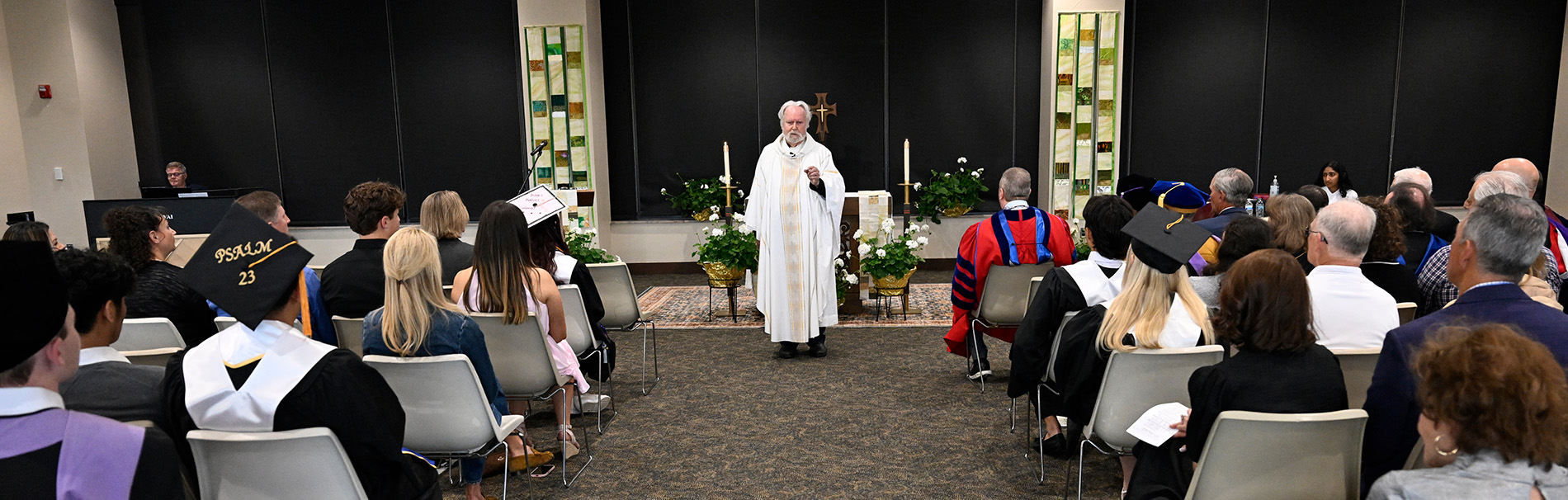 Graduates and other people take part in Commencement Mass.