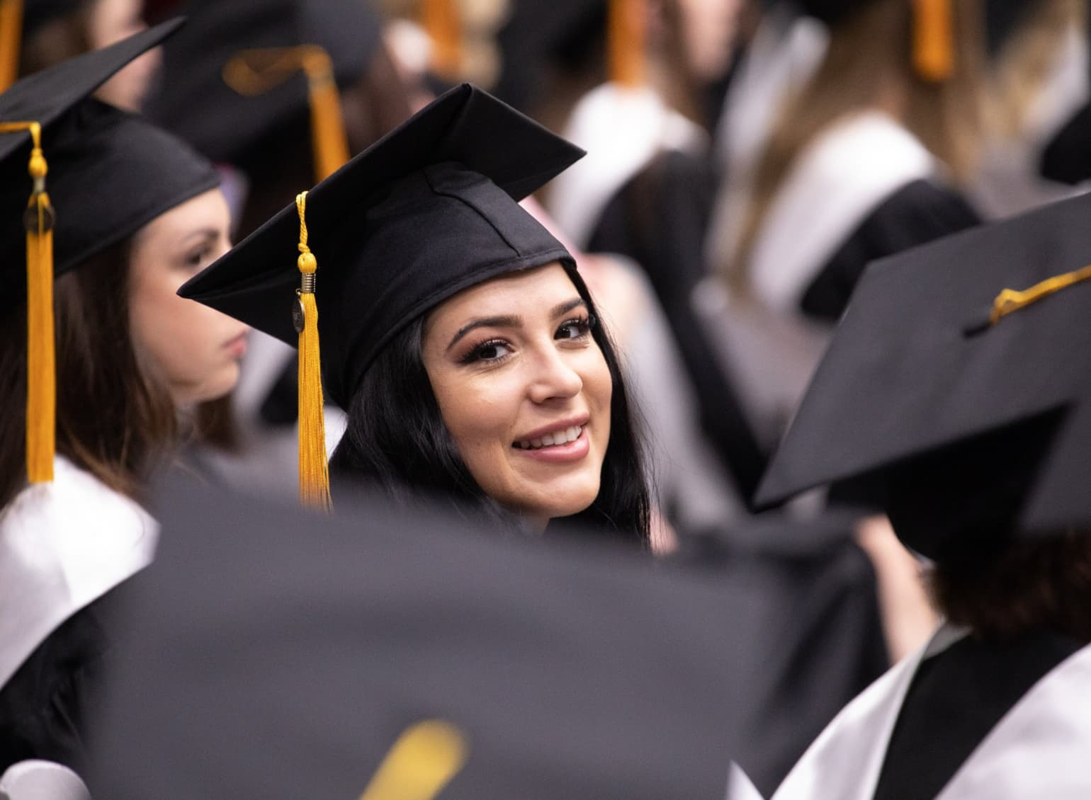 A graduate smiles at commencement.