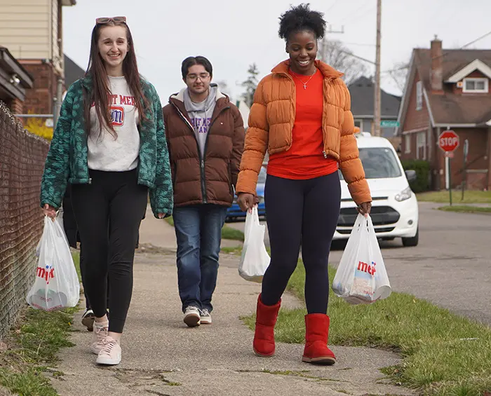students carrying bags of groceries