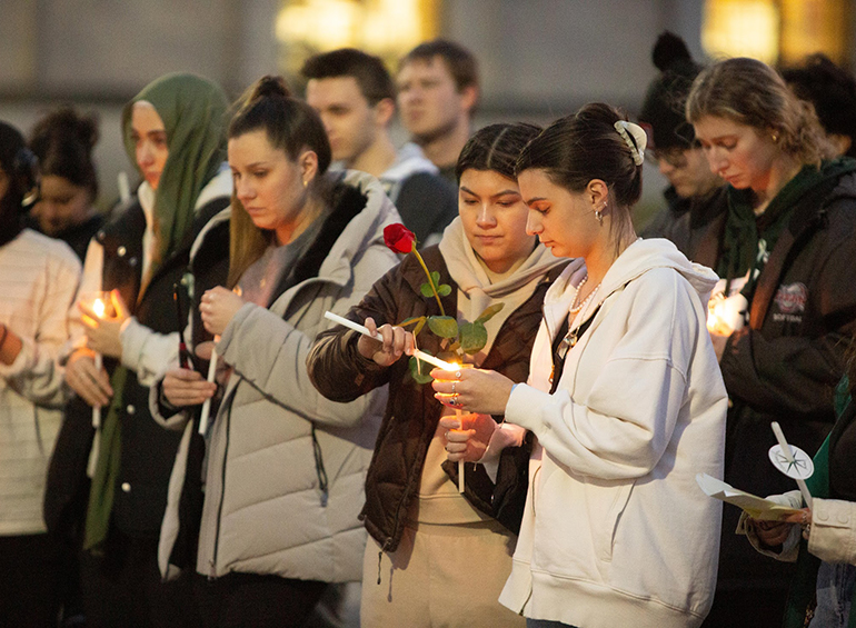 Students holding candles at a vigil 